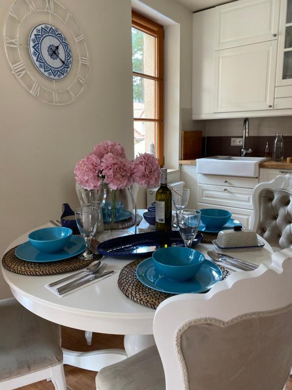 a dining room table with blue dishes on it at Baltic Luxury Nature Home 13 in Pobierowo