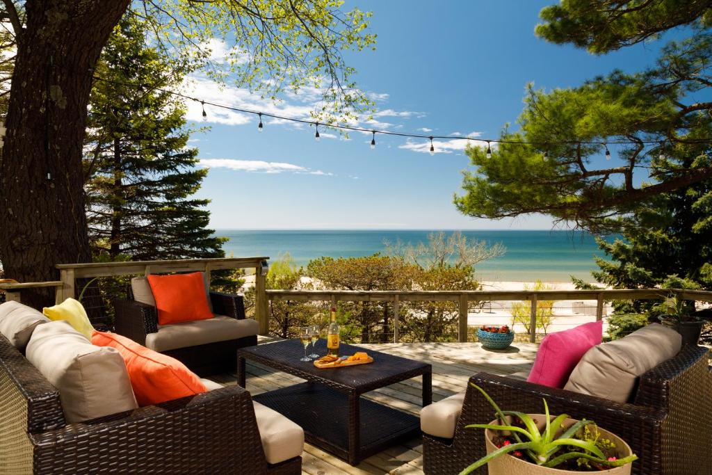 a patio with chairs and a table with a view of the ocean at Looking Glass Beachfront Inn in Grand Haven