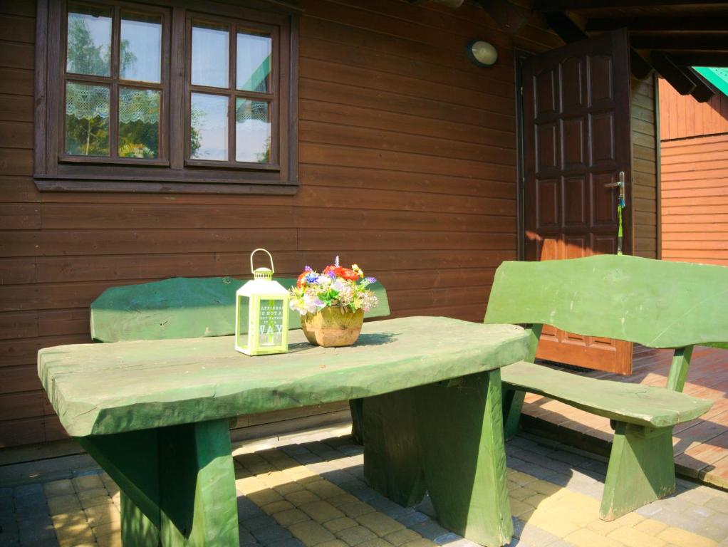 a picnic table with two chairs and a lantern and flowers at Agroturystyka Pod Jesionem2 in Władysławowo