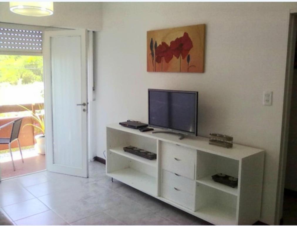 una sala de estar con un televisor en un armario blanco en Silviandres 1 de Villa Gesell