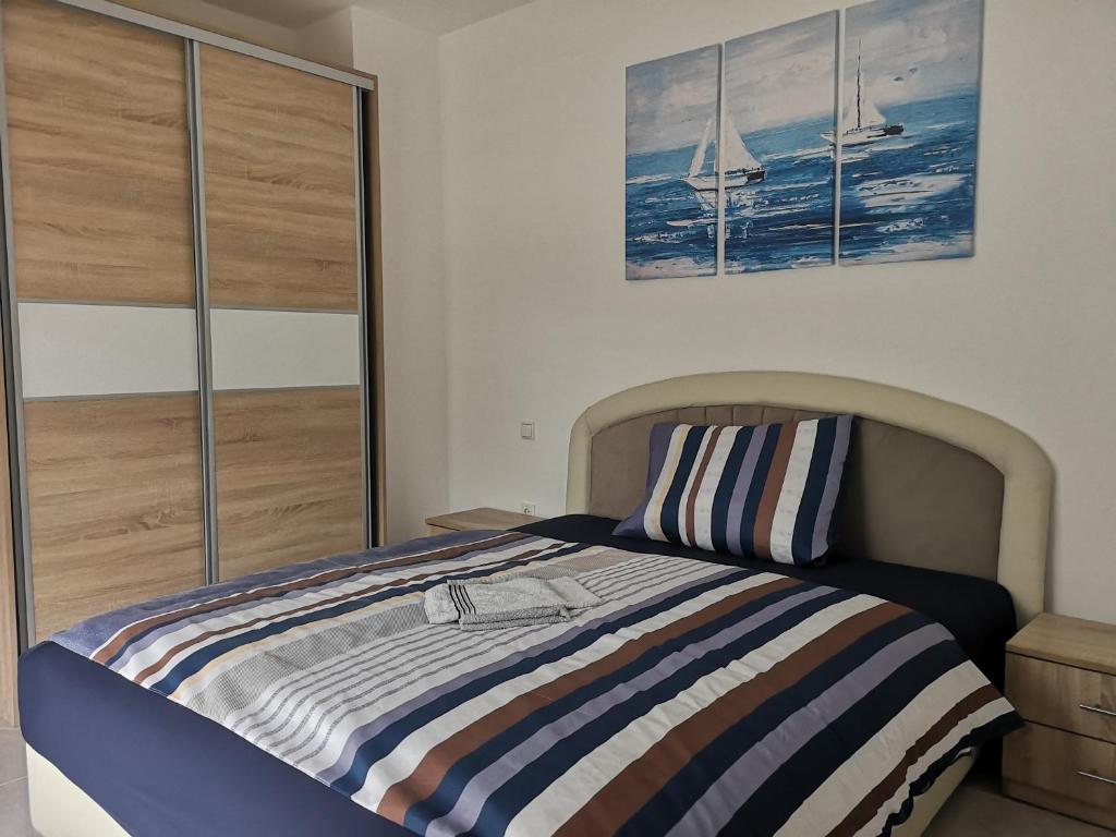 a bedroom with a bed with a striped blanket at Apartment La Mia in Tuzla