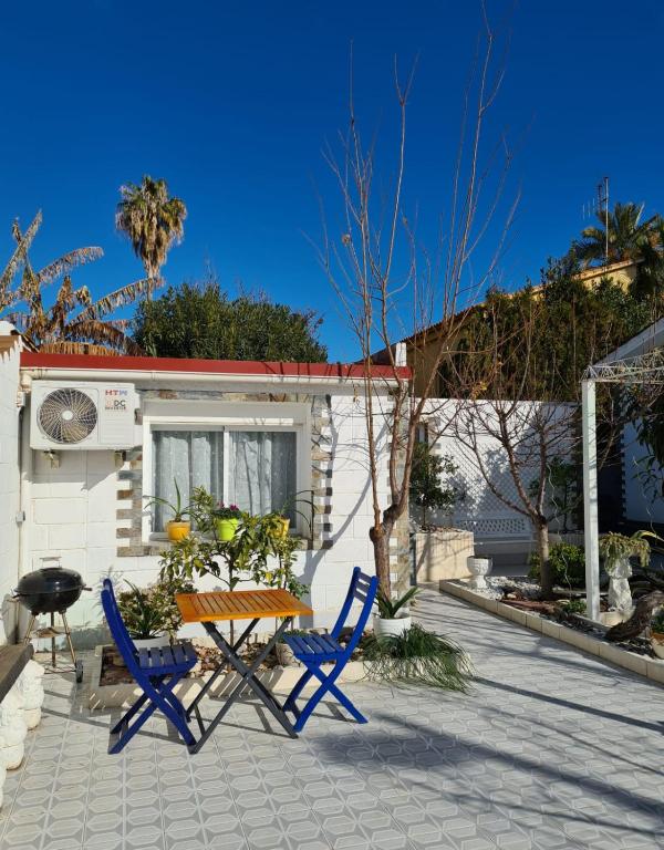 un patio con 2 sillas azules y una mesa en Casa Coqueta, en Almarda