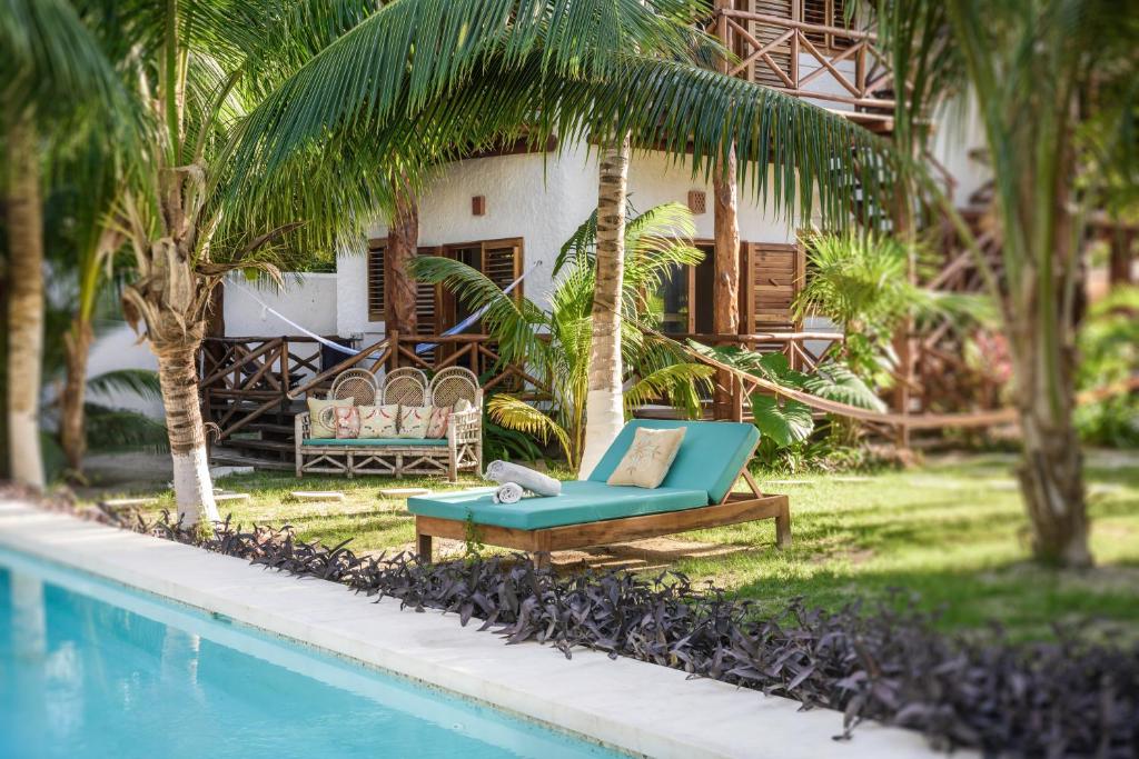 a green lawn chair sitting in front of a pool at Casa Blanca in Holbox Island