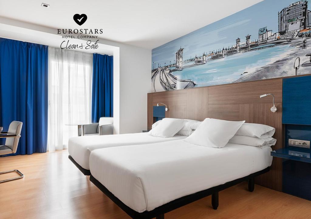 a hotel room with two beds and a painting on the wall at Eurostars Blue Coruña in A Coruña