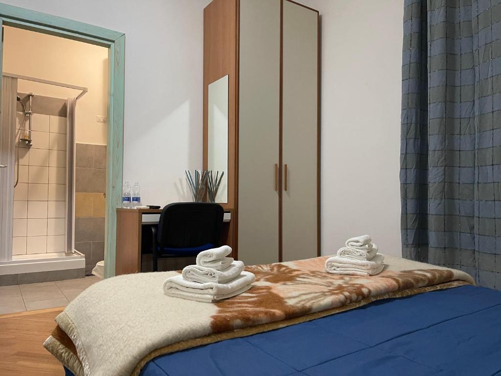 1 dormitorio con 1 cama con toallas en B&B Le Ginestre, en Colleferro