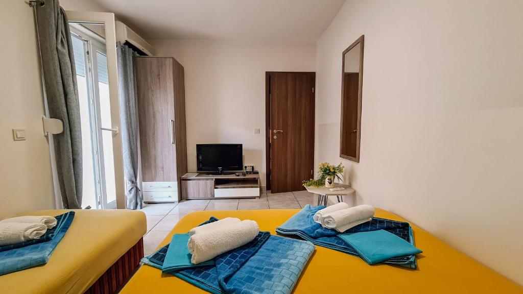 two twin beds in a room with a television at Apartments Maša in Budva