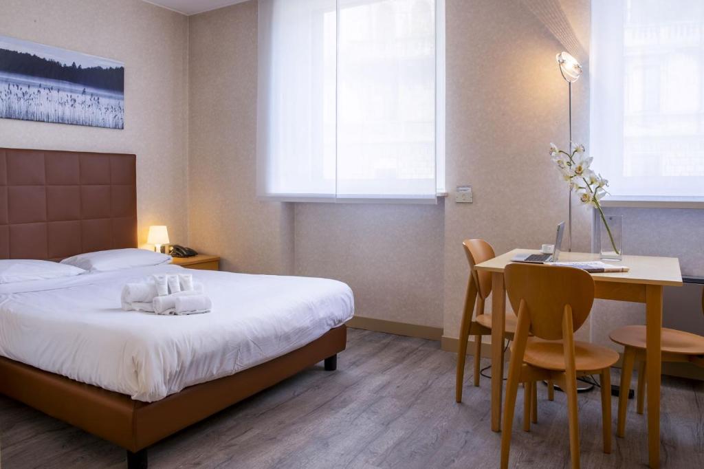 Una habitación de hotel con una cama, una mesa y sillas. en Residence Cimarosa, en Milán