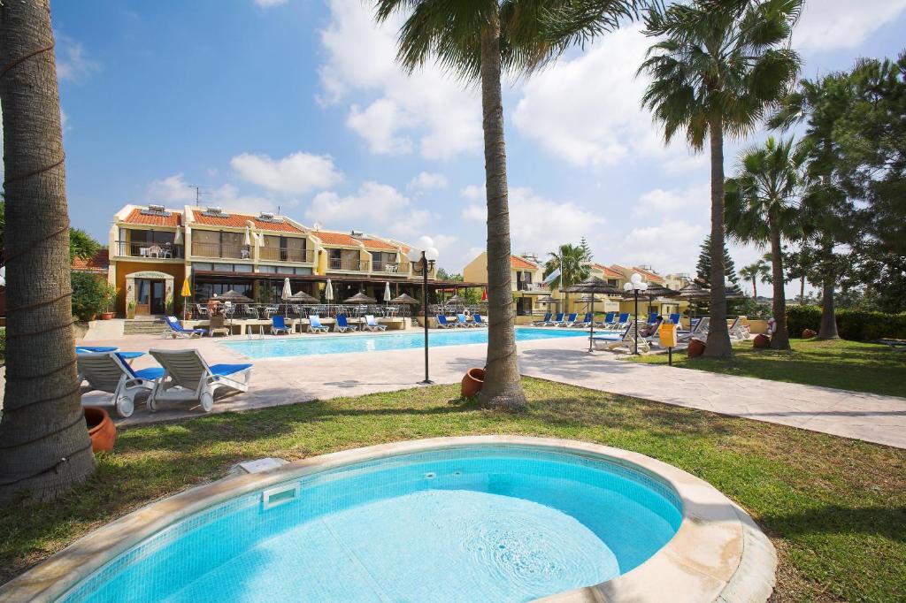 una piscina con palmeras y un complejo en Club Aphrodite en Erimi