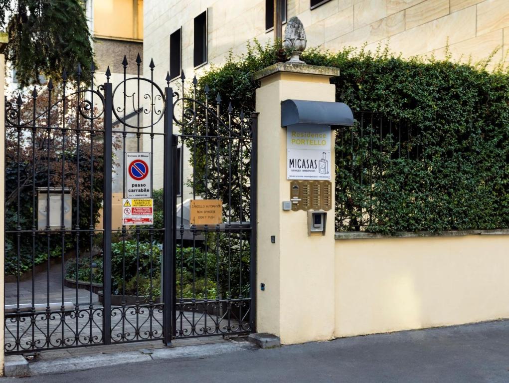 a gate with a sign on it next to a building at Residence Portello in Milan
