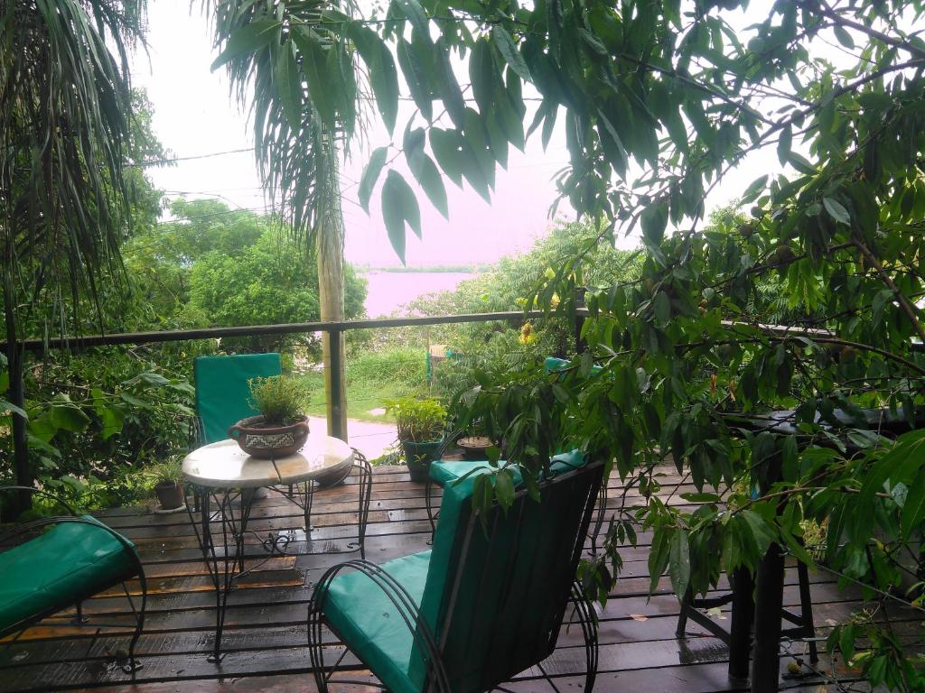 a patio with chairs and a table and trees at Barranca del Paraná in Paganini