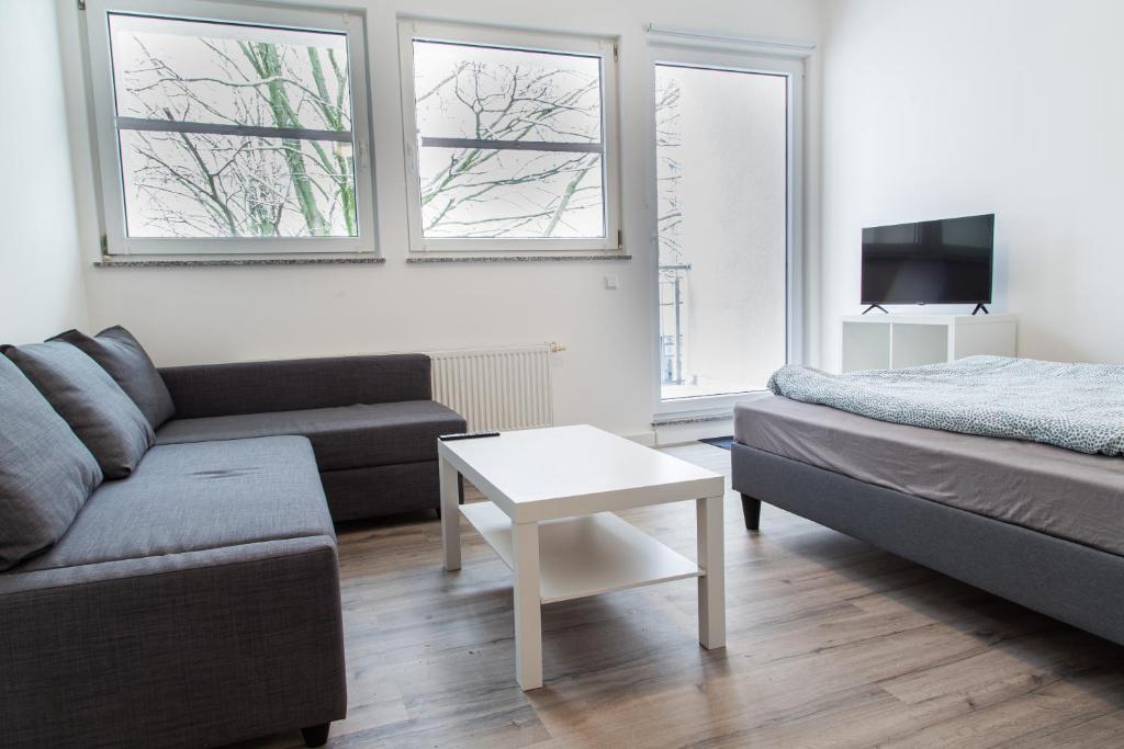 a living room with a couch and a bed and a table at NorthApartments Chemnitz in Chemnitz