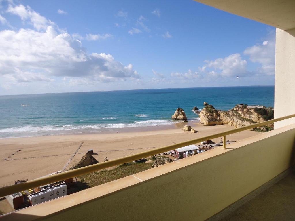 einen Balkon mit Blick auf den Strand und das Meer in der Unterkunft Apartamentos Varandas da Rocha in Portimão