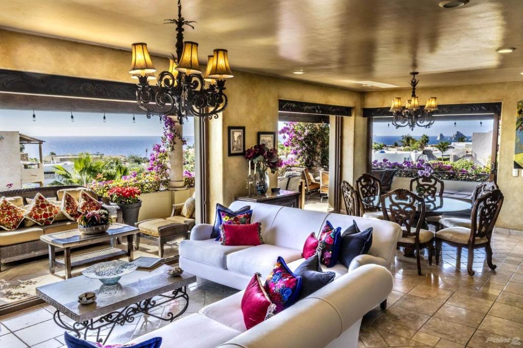 a living room with white couches and a dining room at Villa Lucia Arch and Lands End Views - 4200 sq ft Luxury Villa in Cabo San Lucas