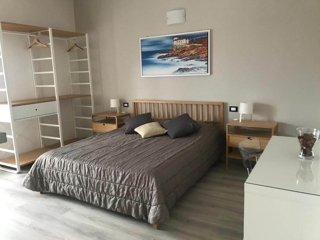 a bedroom with a bed and a desk and shelves at ATTICO LIVORNO Bed & Relax in Livorno