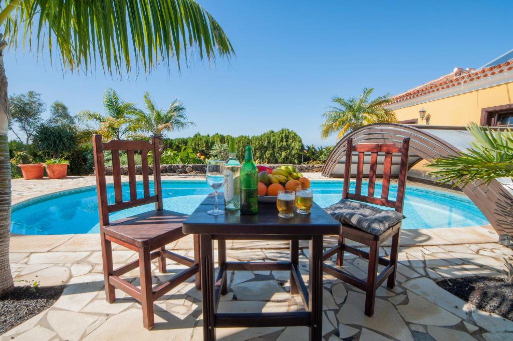 a table with fruit and drinks on it next to a pool at CASA VAN DE WALLE in Tijarafe
