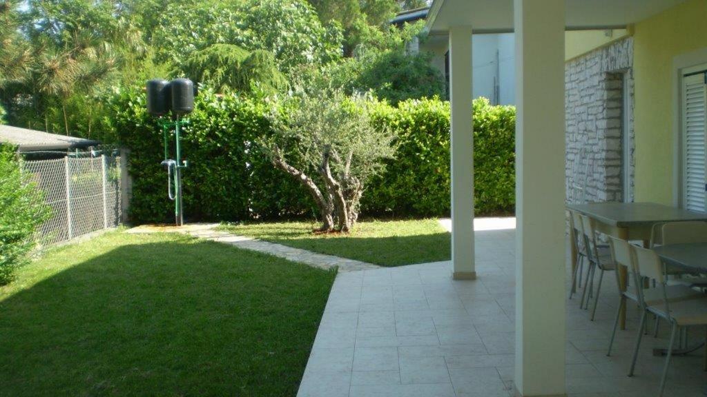 a patio with a table and a grass yard at Apartments Victoria in Savudrija