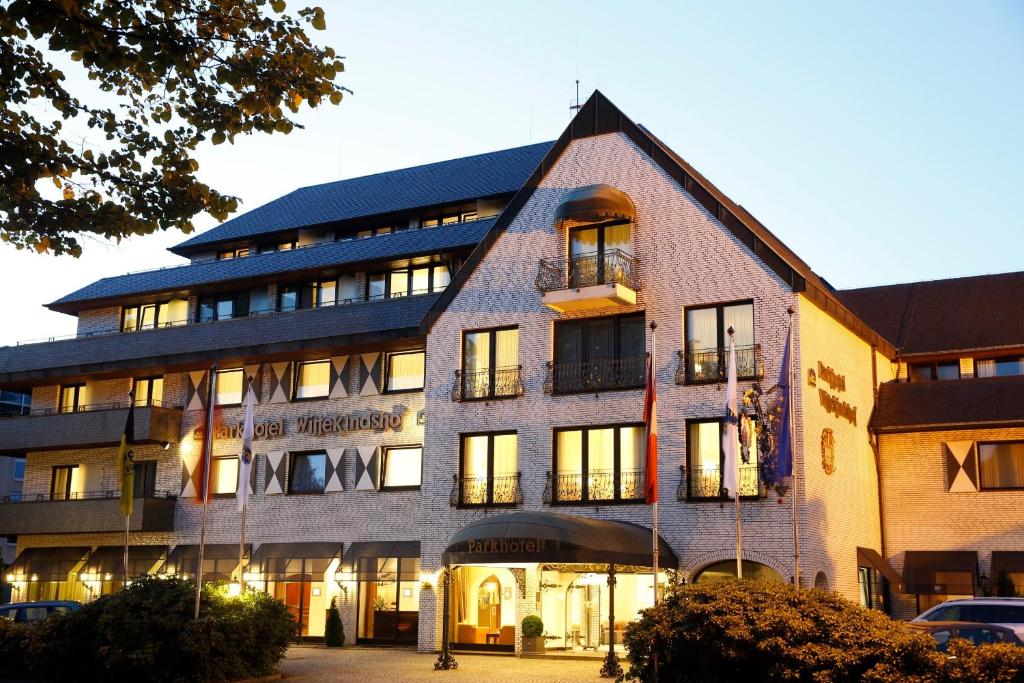 un edificio con luces encendidas delante de él en Parkhotel Wittekindshof en Dortmund