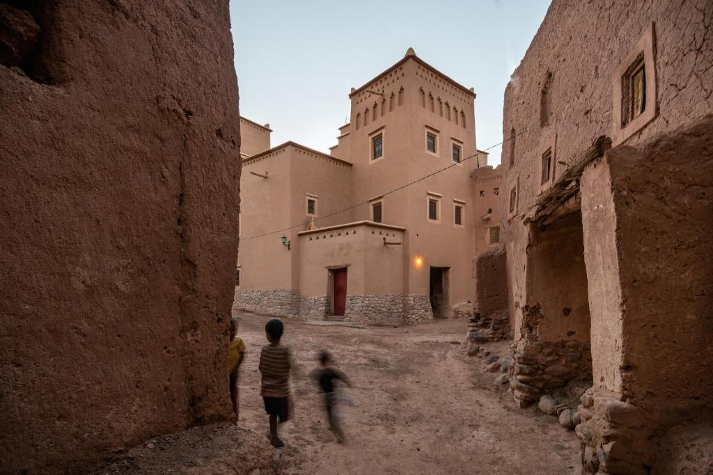 two children walking through an alley in an old building at Dar Bladi in Ouarzazate