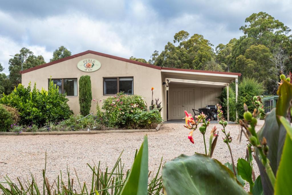 a house with a garage in front of it at Altona Garden Retreat in Spreyton