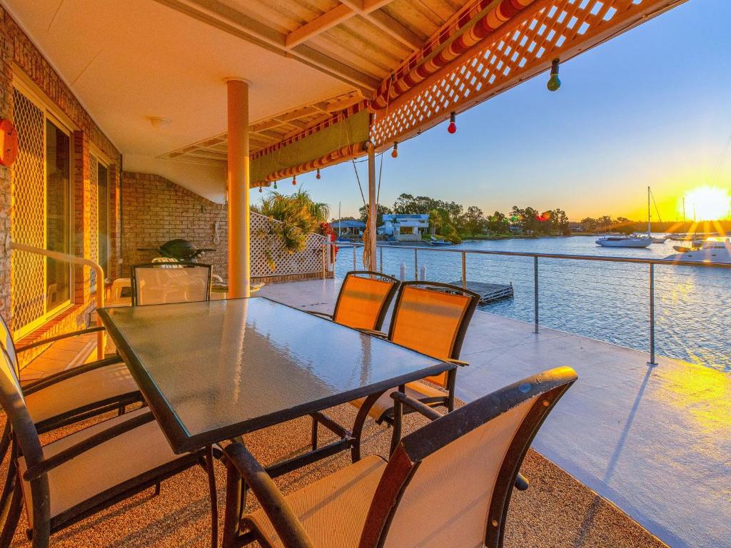 a table and chairs on a porch with a view of the water at Seachange in Yamba