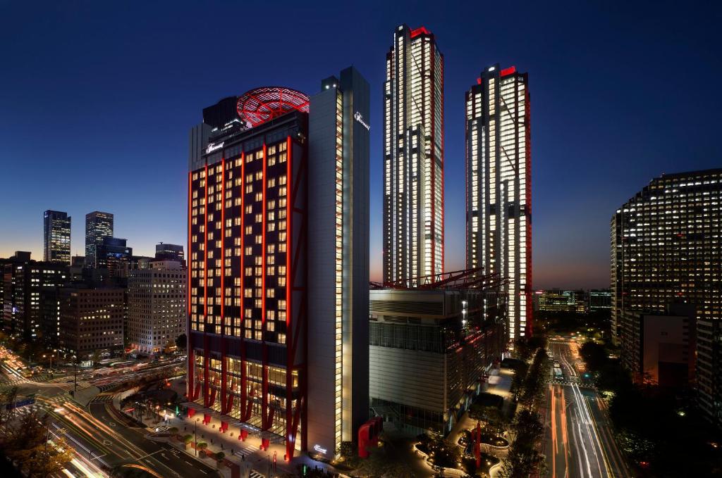 ソウルにあるFairmont Ambassador Seoulの夜の都市の高層ビル2棟