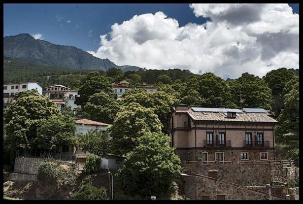 eine Gruppe von Gebäuden und Bäumen in einer Stadt in der Unterkunft Hotel Rural El Paraiso de Gredos in Cuevas del Valle