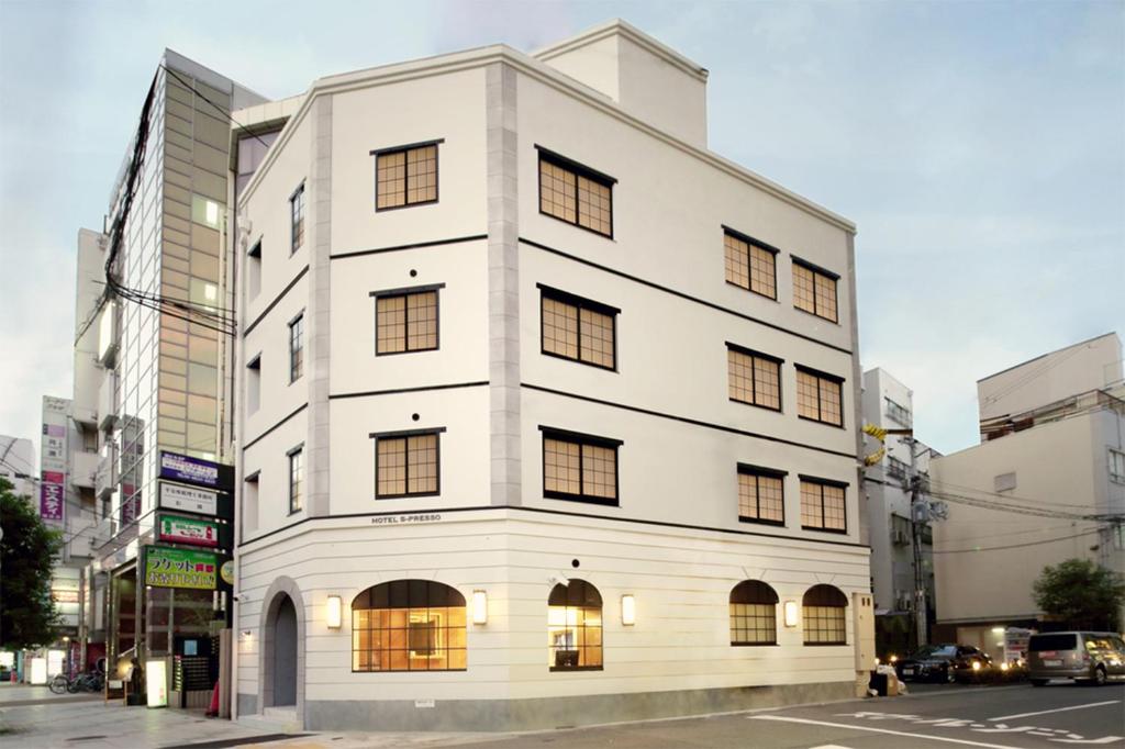 un edificio blanco con ventanas en una calle de la ciudad en Hotel S-Presso Namba, en Osaka