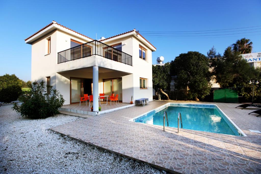 a house with a swimming pool in front of it at Villa Elina in Paphos City