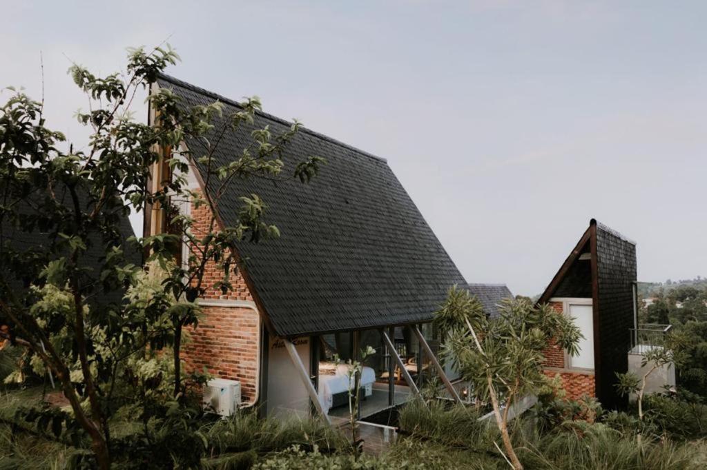 a brick house with a black roof at villa tibra in Lembang