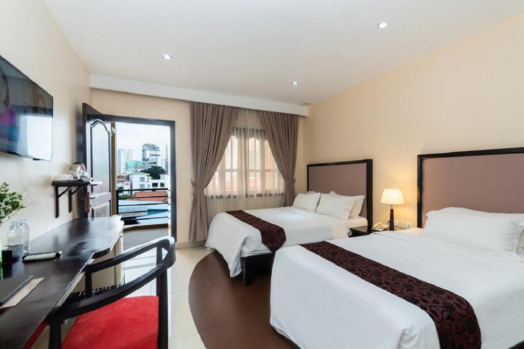 Postel nebo postele na pokoji v ubytování Almond Hotel Sothearos