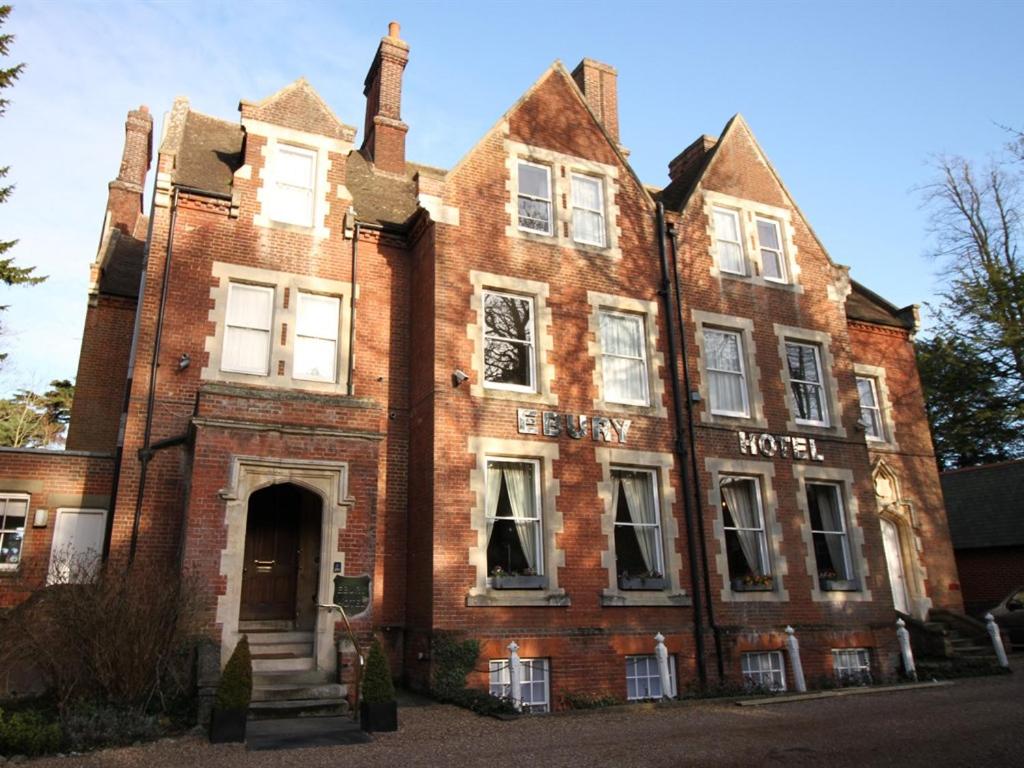 un viejo edificio de ladrillo rojo con un cartel en él en Ebury Hotel Cottages and Apartment's, en Canterbury