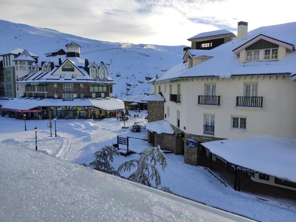 un groupe de bâtiments avec de la neige sur les toits dans l'établissement Plaza Andalucía Edificio Salvia 2-6 pax, à Monachil