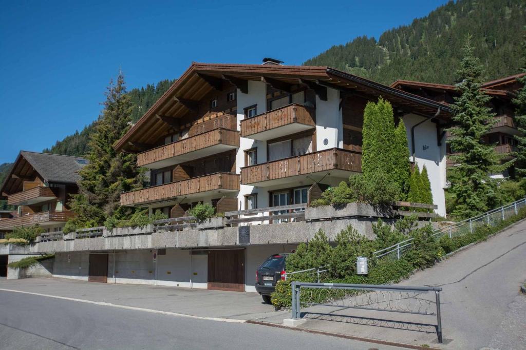 un bâtiment avec une voiture garée devant lui dans l'établissement Ferienwohnung Helios, à Adelboden