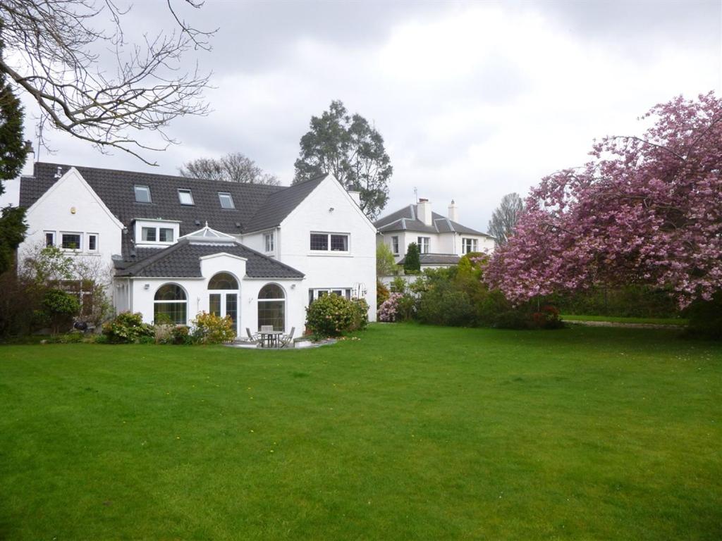 una casa blanca con un patio con césped verde en Carmichael, en Edimburgo