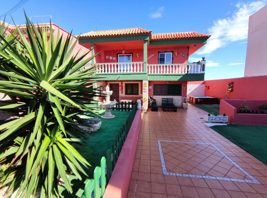 a red house with a patio and a yard at Casa Cielito Lindo in Las Eras