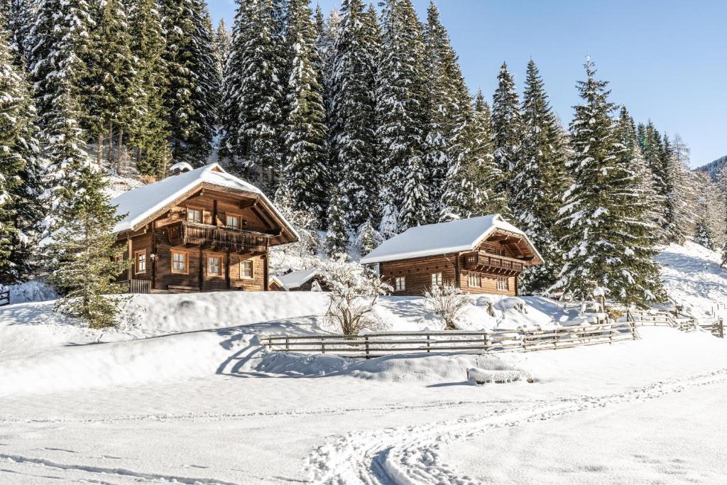 un paio di case di tronchi nella neve di Gasserhütte a Innerkrems