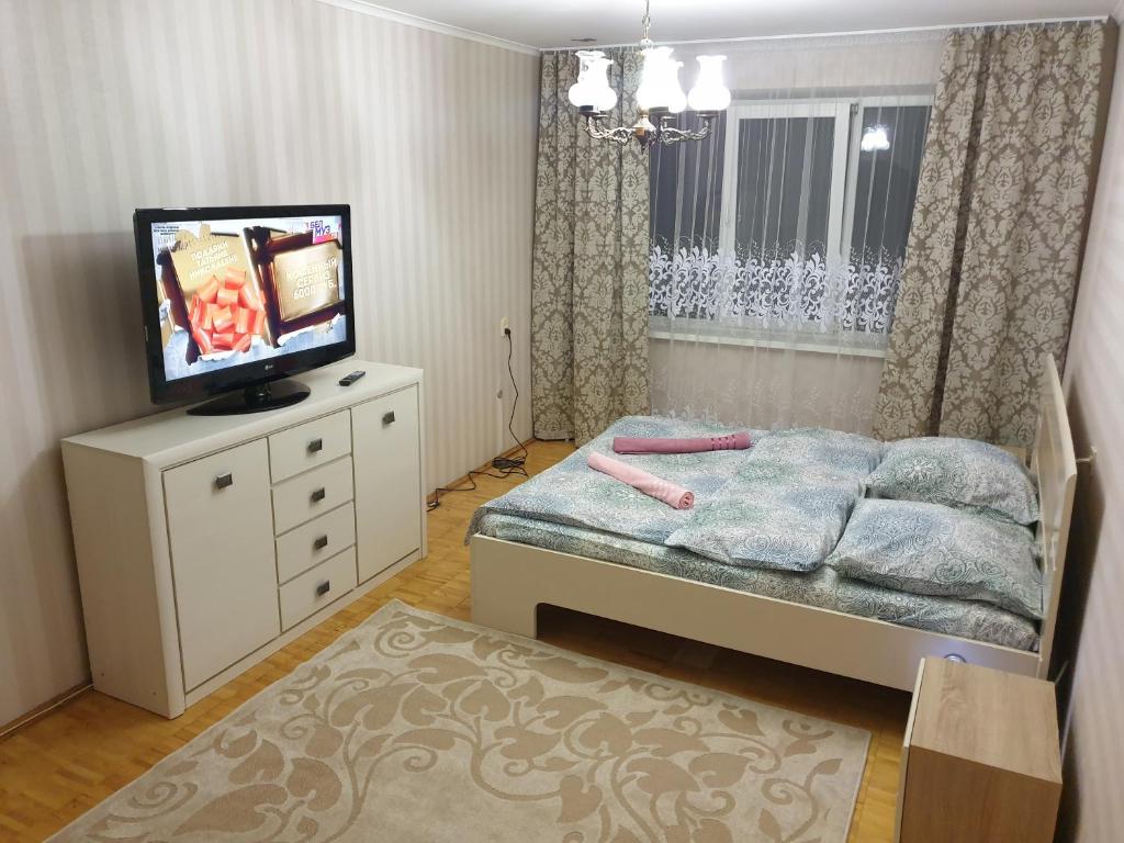 a bedroom with a bed and a tv on a dresser at Пинск ул. Центральная 3A-MANGO in Galevo