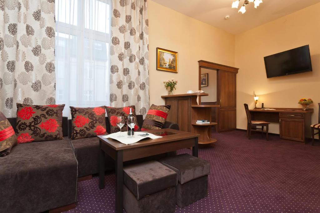 a living room with a couch and a table at Hotel Maksymilian in Krakow