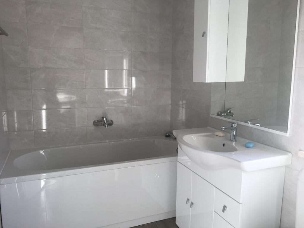 a bathroom with a white tub and a sink at Apartments Lumbarda in Lumbarda