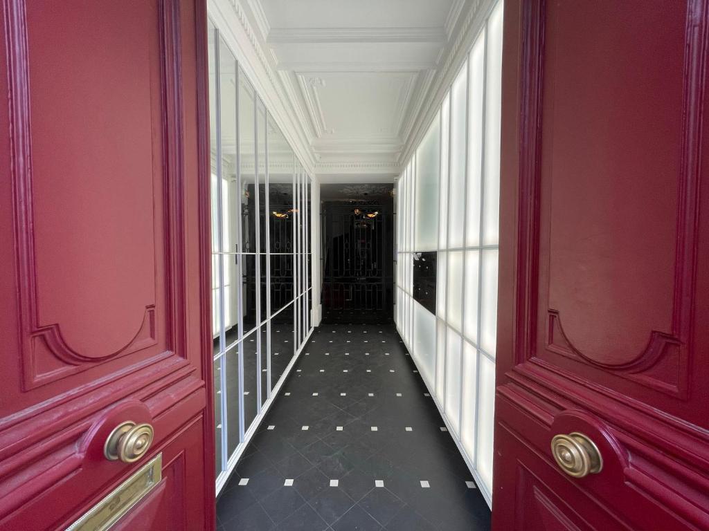 un couloir d'un bâtiment aux murs rouges dans l'établissement RESIDENCES HARCOURT - Ile Saint Louis - PARIS, à Paris