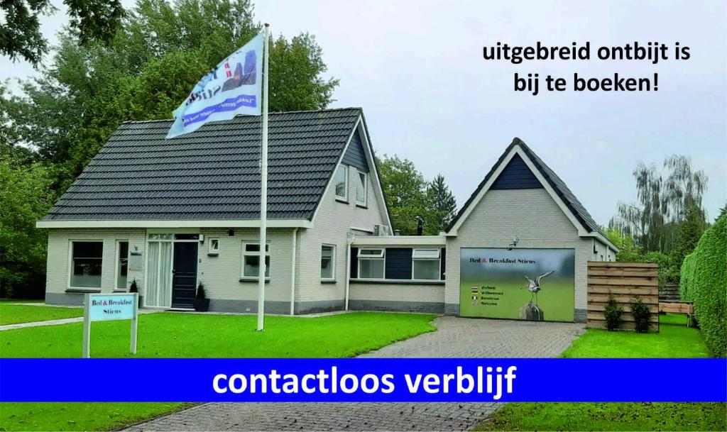 una casa con una bandera delante de ella en Bed & Breakfast Stiens (nabij Leeuwarden), en Stiens
