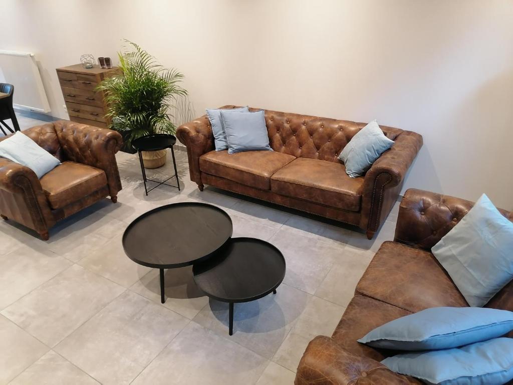 a living room with leather couches and a table at The Front Door N28 in Ieper