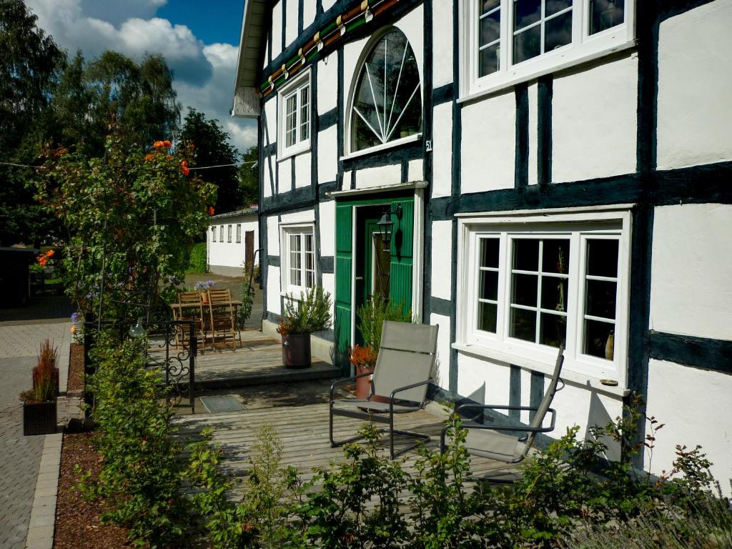 a white and green building with chairs in front of it at LandArt in Olpe