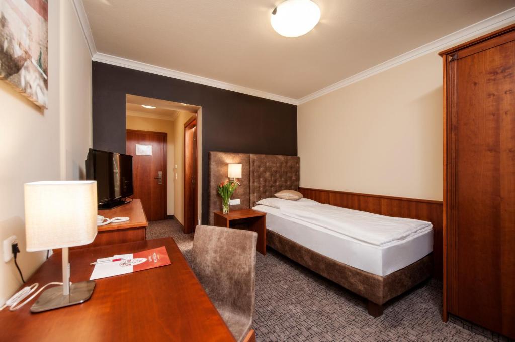 een hotelkamer met een bed en een bureau bij Hotel Weinberg GmbH 
