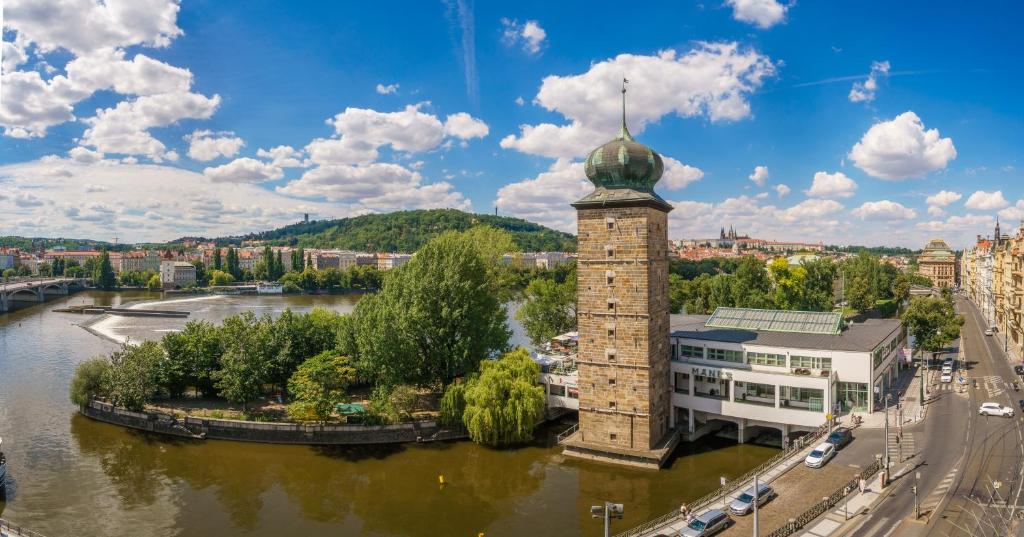 rzeka z wieżą w środku miasta w obiekcie MN6 Luxury Suites by Adrez w Pradze