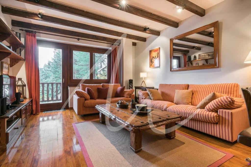 Sala de estar con 2 sofás y mesa en Amitges by SeaMount Rentals, en Naut Aran (Alto Arán)