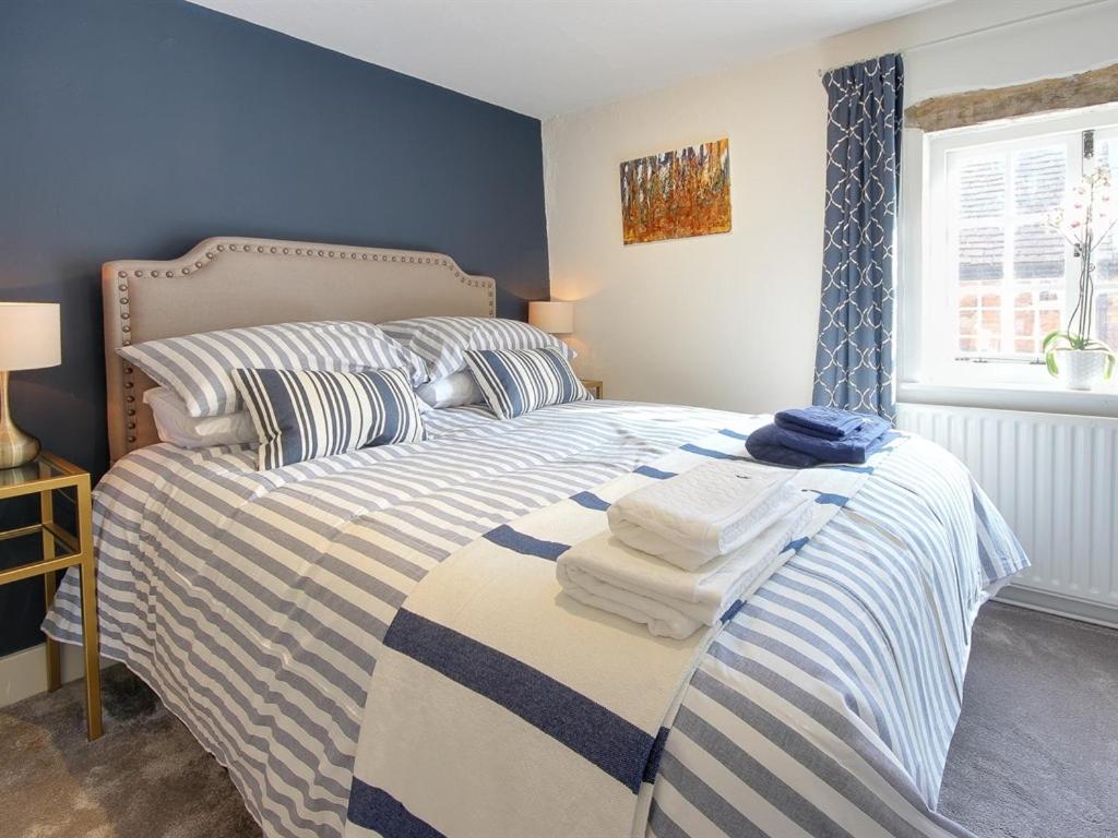 a bedroom with a bed with towels on it at Cartref in Farnham
