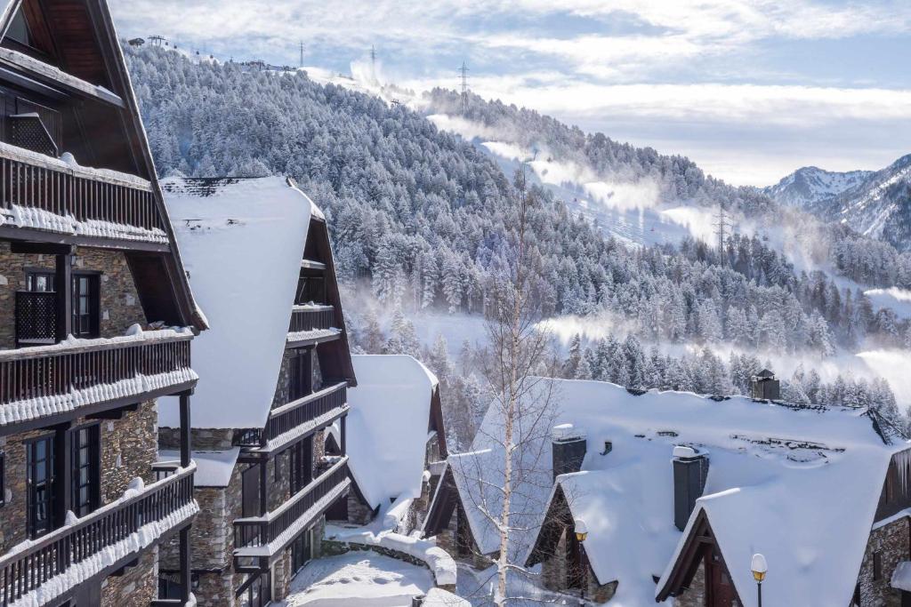 uma vista para uma montanha coberta de neve a partir de um edifício em Nin de Beret by SeaMount Rentals em Naut Aran