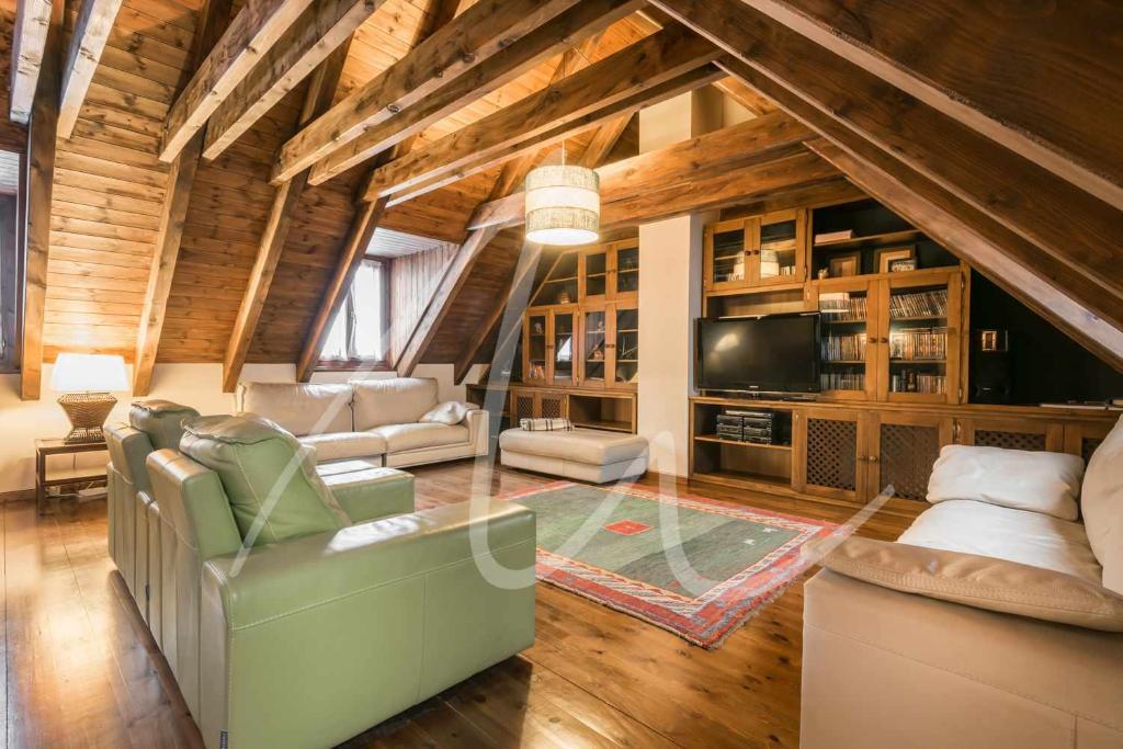 ein großes Wohnzimmer mit Sofas und einem TV in der Unterkunft Casa Eth Gauèc by SeaMount Rentals in Vielha e Mijaran