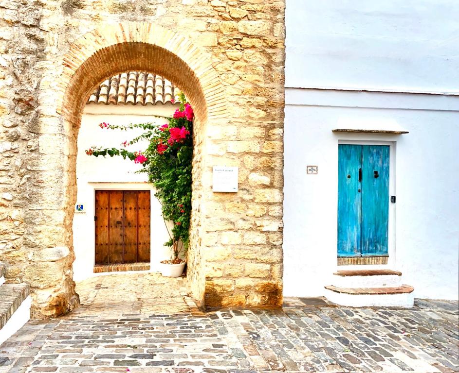 two doors on the side of a building with flowers at CASA PUERTA AZUL Absolutely the Best of Vejer! Casas Vejer Debra in Vejer de la Frontera